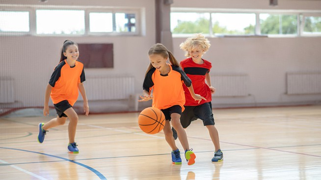 youth girls basketball players performing fun basketball drills