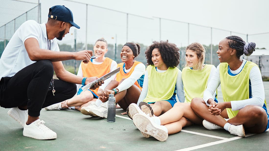 Safesport – april article header image Image of coach talking with his athletes on basketball court