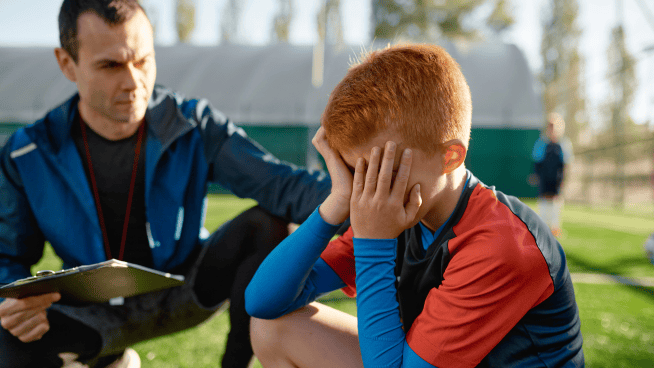 stack.com – upset athlete not getting playing time young male soccer player upset and being consoled by coach